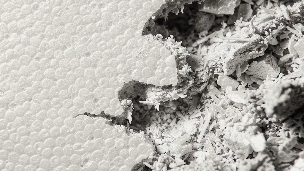 Extreme close-up macro photograph of crushed expanded polystyrene foam showing compressed cell structure and fracture patterns in a helmet liner