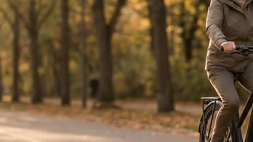 A senior cyclist confidently riding a modern step-through e-bike along a quiet tree-lined path at golden hour